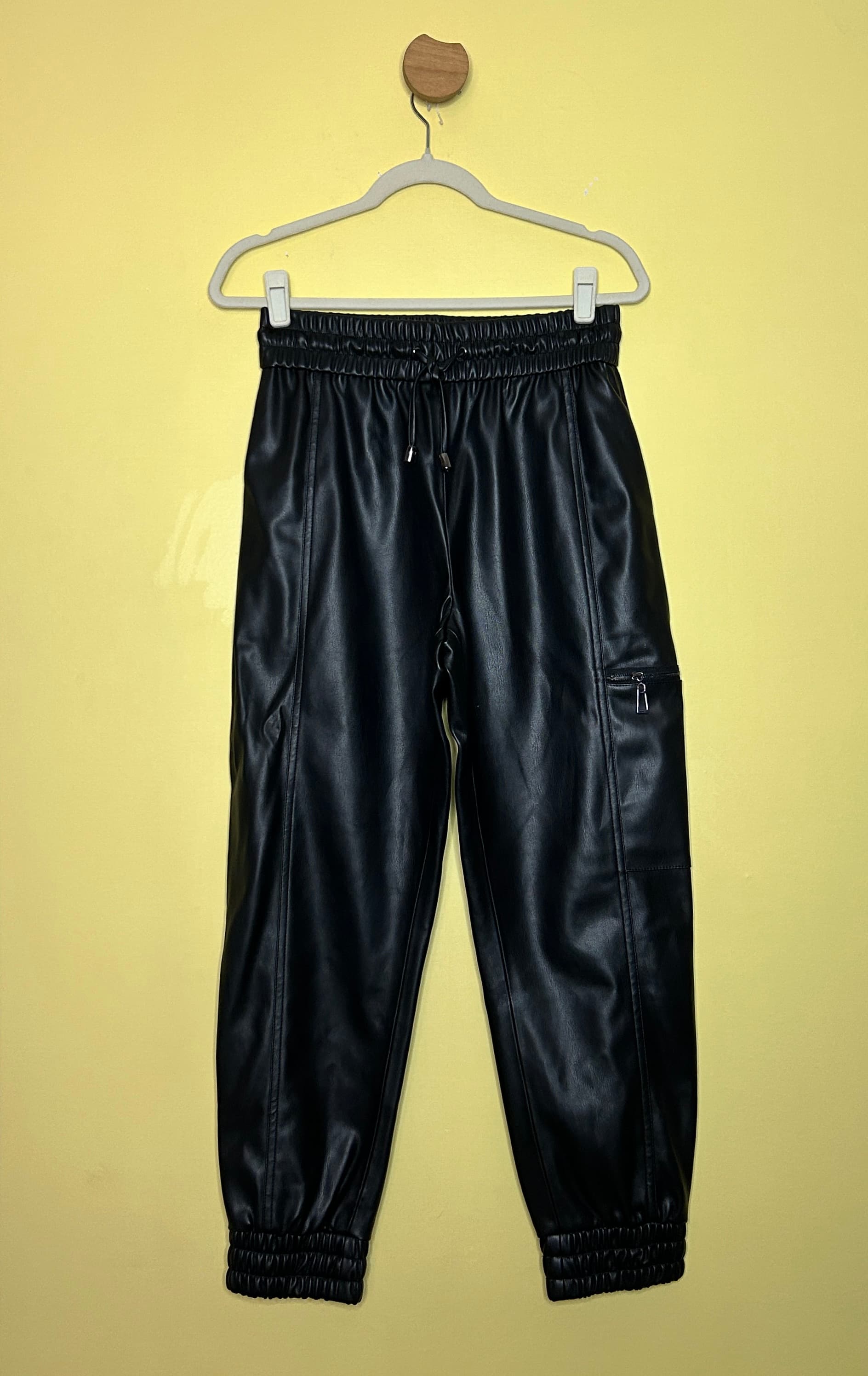 Calça jogger couro ecológico zíper bolso